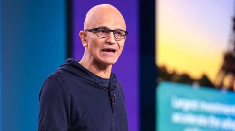 Satya Nadella on stage in a hoodie