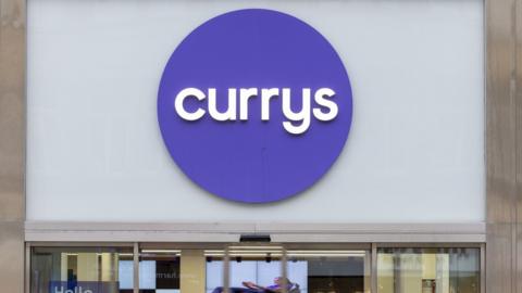 A person walks past Currys