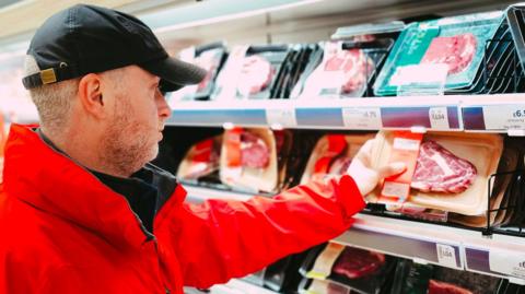 A man shopping for meat in a supermarket
