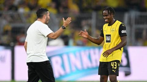 Jamie Gittens  is congratulated by Nuri Sahin after scoring both of Borussia Dortmund's goals against Eintracht Frankfurt