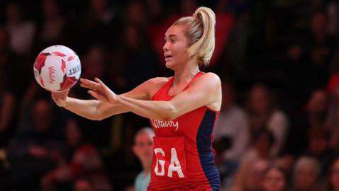 Helen Housby throws the ball during a netball match 