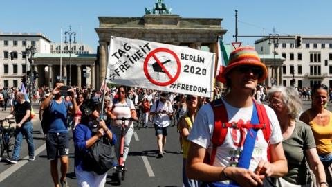 Demonstrators at the Brandenburg Gate with a banner reading Day of Freedom
