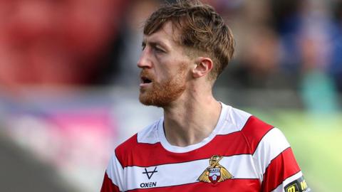 Tom Anderson wearing a Doncaster Rovers shirt