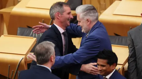 Liam McArthur is congratulated by MSPs in the chamber