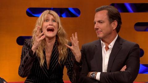 Laura Dern, in a black striped jacket, gestures with her mouth open and hands raised. Will Arnett looks on next to her