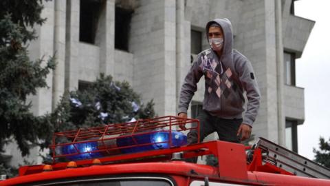 Protester stands on a fire engine in Bishkek on 6 October 2020