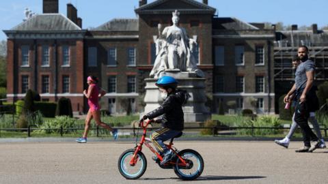 A child cycling wearing a mask