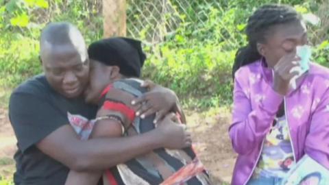 People are seen weeping following the news of a deadly crowd crush at a New Year event in Uganda