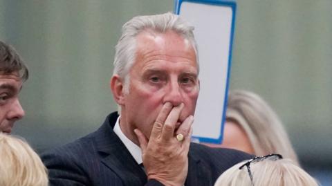 Ian Paisley before losing his seat with his hand over his mouth