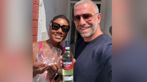 Couple on doorstep with wine