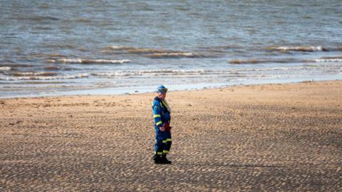 Rescuer on beach wears reflective clothing
