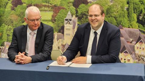 A man sitting next to new Hertfordshire PCC Jonathan Ash-Edwards 