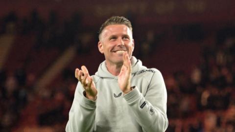 Rob Edwards, with a beaming smile, claps the Middlesbrough fans after their win over West Brom