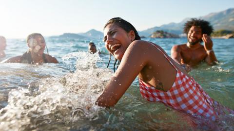A group of friends laughing and swimming