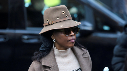 Diezani Alison-Madueke outside Southwark Crown Court in January. She is wearing a brown hat, with matching brown coat and a jumper. She has sunglasses on and earrings.