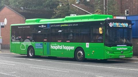 A green Hospital Hopper bus in Leicester