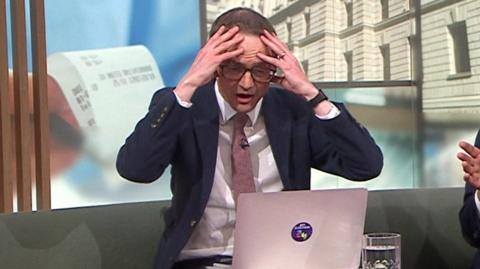 Chris Mason reacts to the leak in the Politic Live studo, with his head in his hands