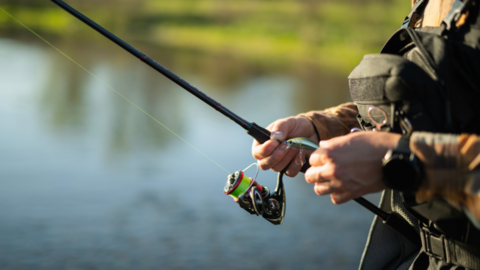 A close-up of a fishing rod in someone's hands
