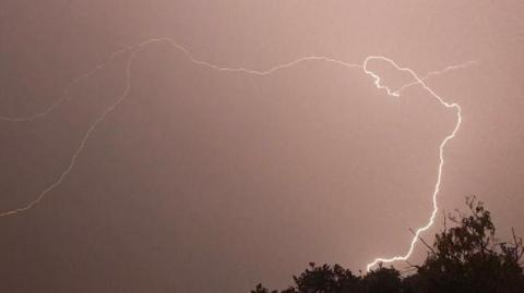 A dramatic bolt of lightning flashing across the night sky in Brentwood.