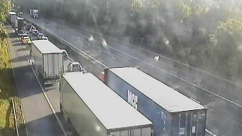 Lorries and cars bumper to bumper on the M11 in Essex in one direction. On the other, some cars are travelling. 