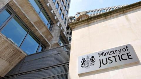 A building with a sign that reads "Ministry of Justice"