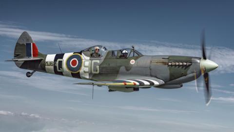 Side view of a Spitfire in the sky with the Royal Airforce emblem on the side.