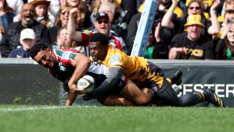 Gabriel Hamer-Webb in the act of getting over the line to score a try for Leicester Tigers despite being wrapped up in a tackle