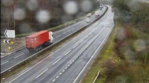 A traffic camera image of the A14 dual carriageway in Suffolk. Vehicles pass along either side of the carriageway.