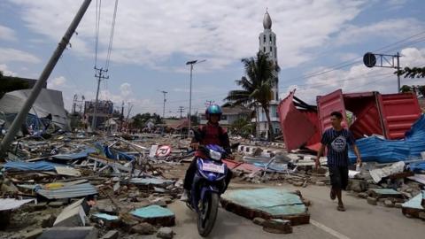 Residents on a street full of debris after an earthquake and tsunami hit Palu, on Indonesia's Sulawesi island.