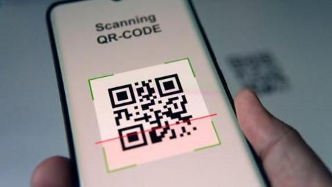 A QR Code being scanned on a mobile phone.