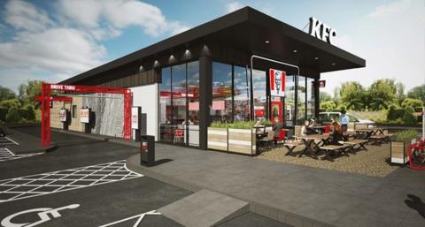 An artist's impression of a KFC restaurant which has a glass front and benches outside the front. It is a black building with a white KFC sign on its roof. There is a red metal archway that says "Drive thru" on it, around the side of the building.