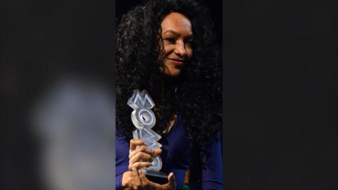 MOBOs founder Kanya King holds one of the awards during the 2026 ceremony.