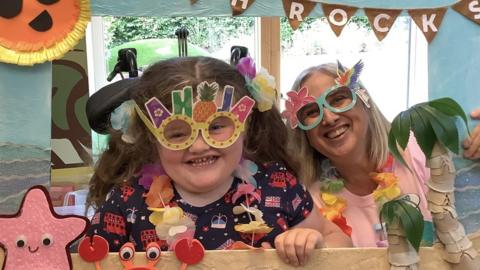 Ellie in fun glasses with Julia's House play worker Lisa Magill at the 'JH Rocks' festival
