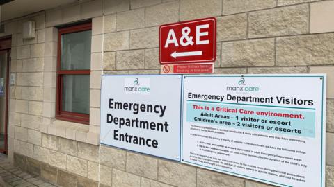 Emegency department entrance sign on brick wall of hospital.