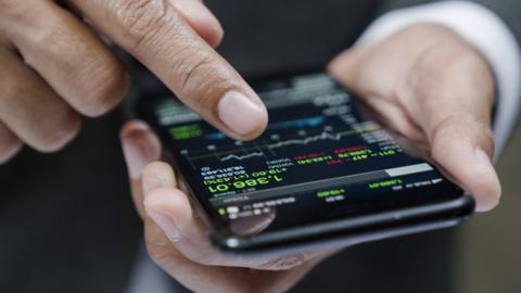 Person using phone to check stock market data