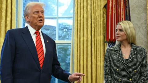 Donald Trump gestures as he speaks, standing in the Oval Office next to Pam Bondi