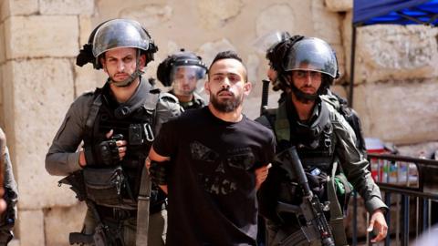 Israeli security forces detain a man at the entrance of Jerusalem's al-Aqsa mosque compound, on May 21, 2021