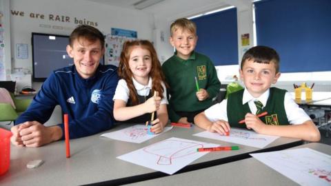 Football coach Danny Strachan with school pupils.