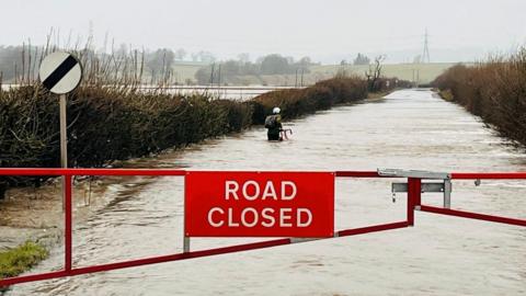 A cyclist wades through flood water in Coupar Angus area.