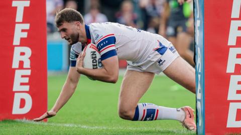 Josh Rourke diving in between the posts to score a try for Wakefield