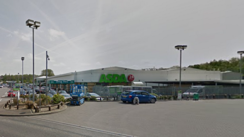 A blue car parked outside Asda supermarket where the furniture shop is located