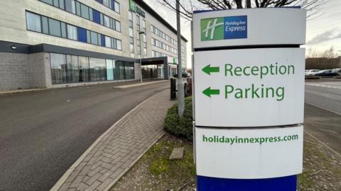 The outside of the Holiday Inn Express in Manvers, Rotherham, with a sign pointing to the car park and reception.