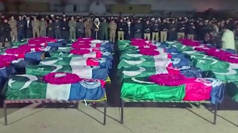 Lines of coffins draped in Pakistan flags