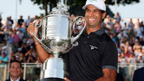 Aaron Rai holds the trophy
