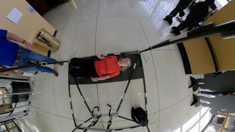 Woman with blonde hair lying down near a rope ladder