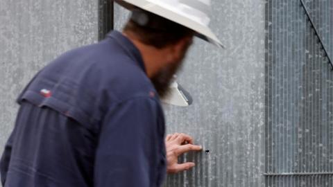 Duke Energy workers inspect an apparent bullet hole