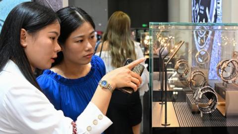 Chinese shoppers look at watches in Haikou, China.