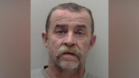 Zvonko Tomisa, who has short hair and a bushy moustache, in a police mugshot.