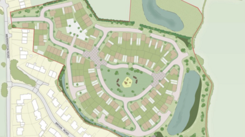 A plan of a green area with houses and roads marked on it and an area in the centre with two concentric circular roads.