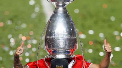 A Bayern Munich player with a trophy on his head